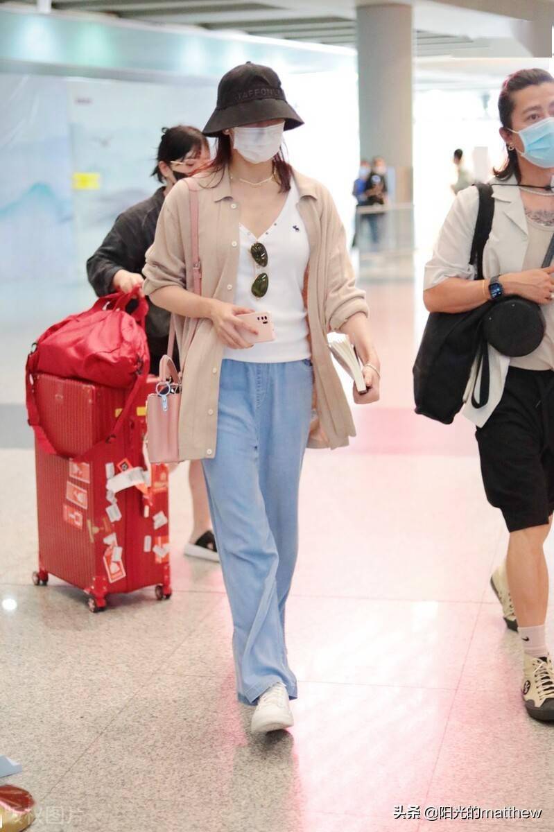胡静戴渔夫帽现身机场穿紧身上衣搭配粉色针织外套长裤休闲随性