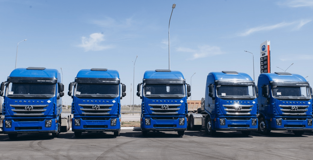 整齐排列的蓝色红岩杰狮c6 lng牵引车车阵,在广阔蓝天的映衬下,愈发