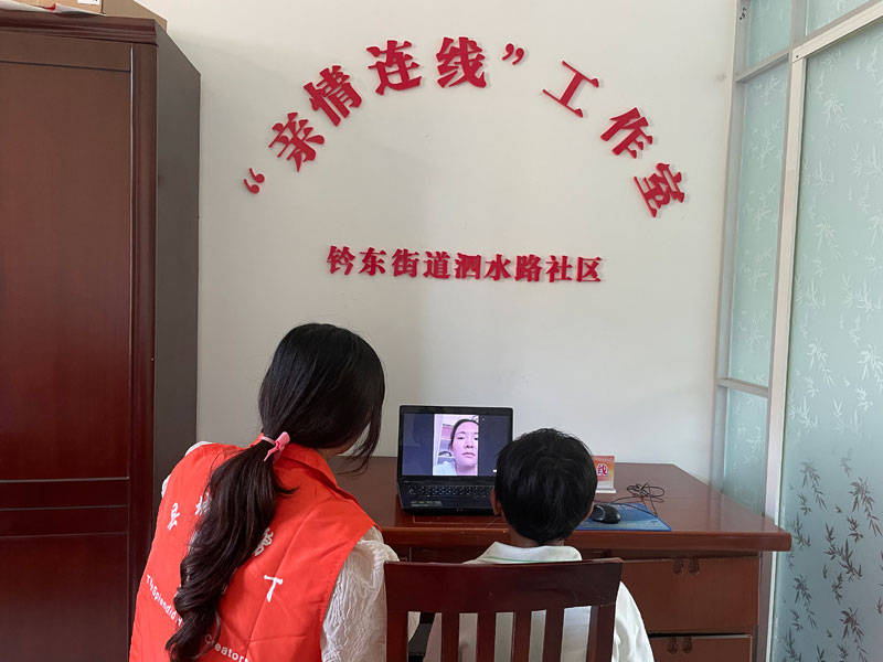 志愿者在"亲情连线工作室"为留守儿童连线在外工作的父母