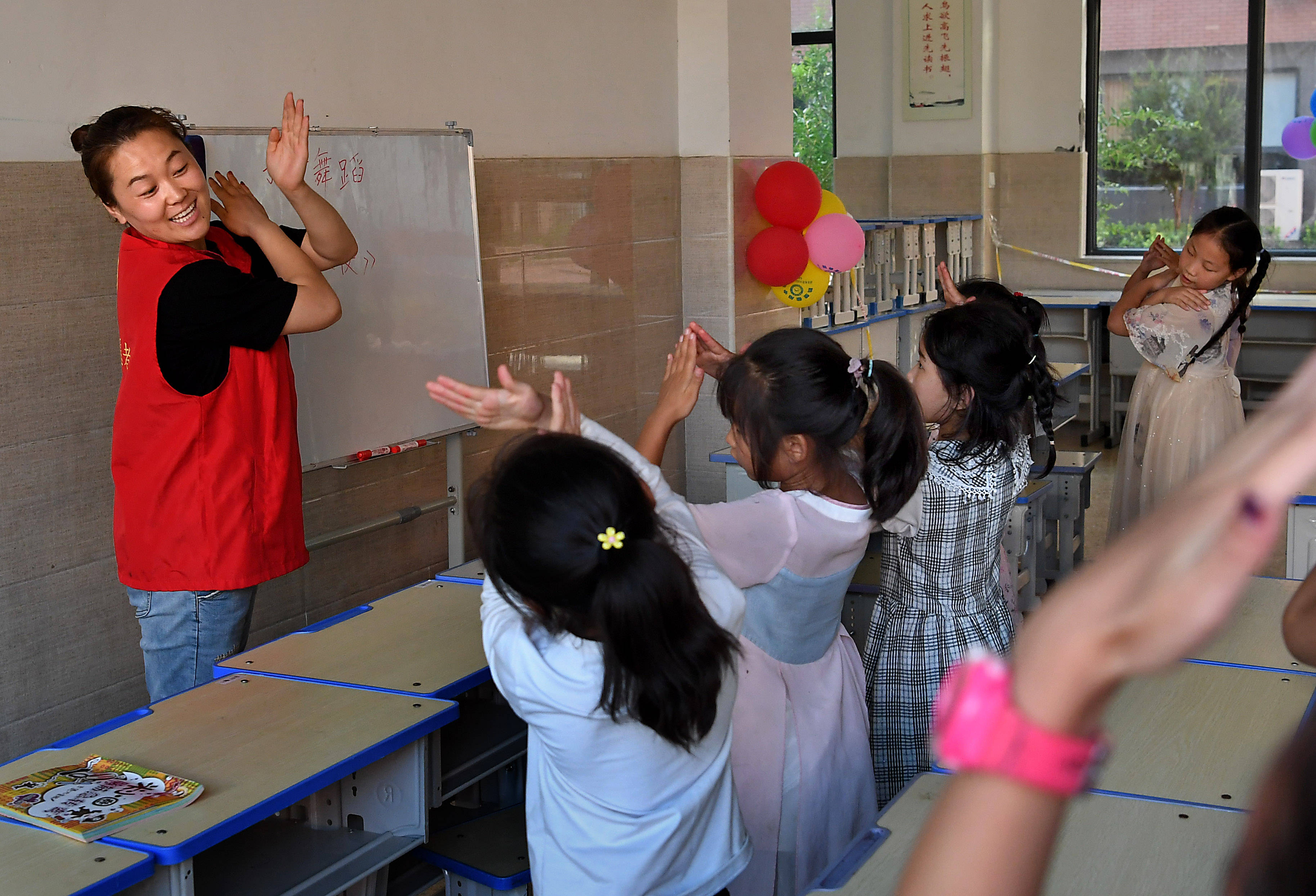 在河南省鹤壁市浚县黎阳中学长丰校区安置点,志愿者带领小朋友学习