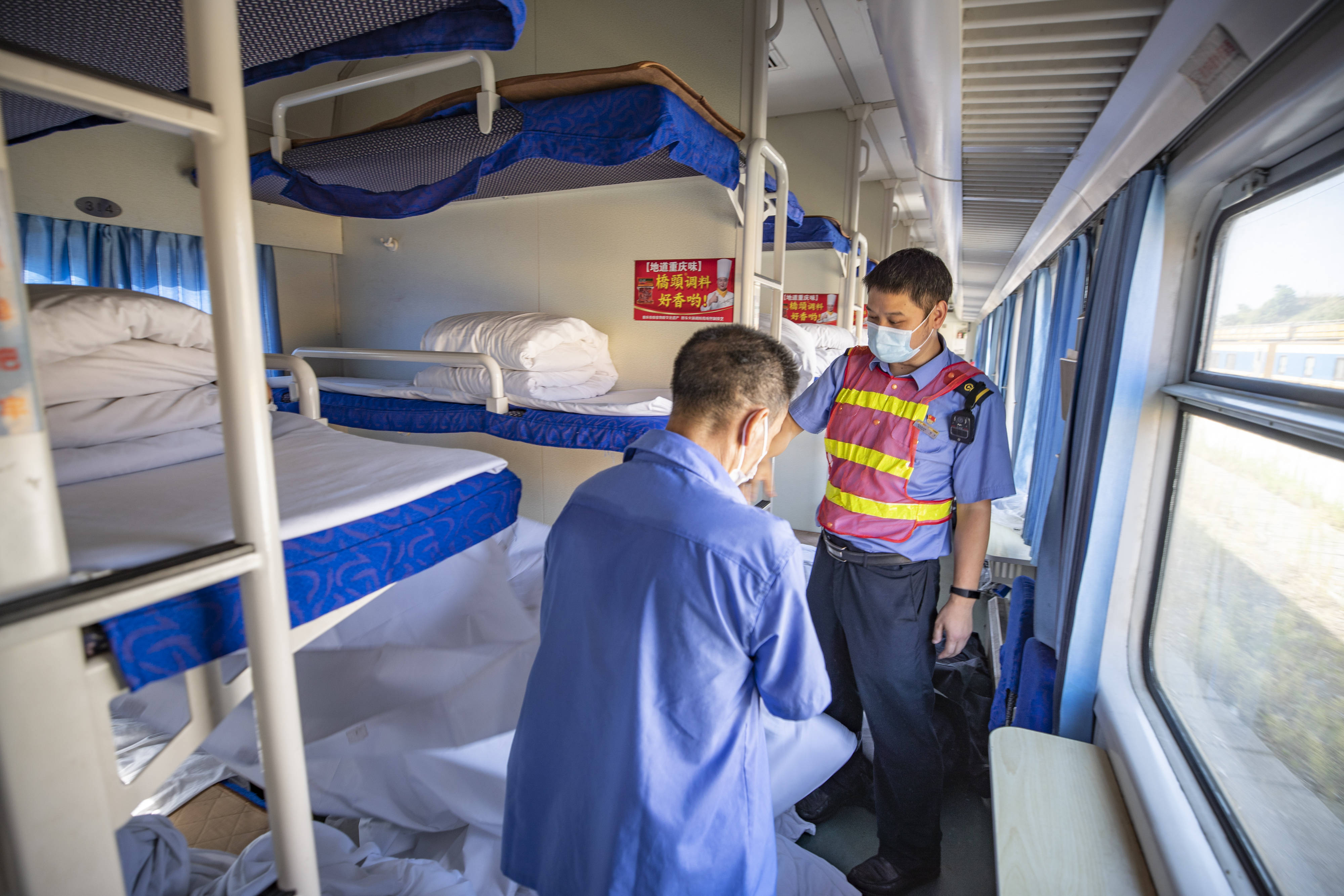 8月3日,在k1153次列车入库途中,守车车长杨峰(右)帮助库内保洁员对全