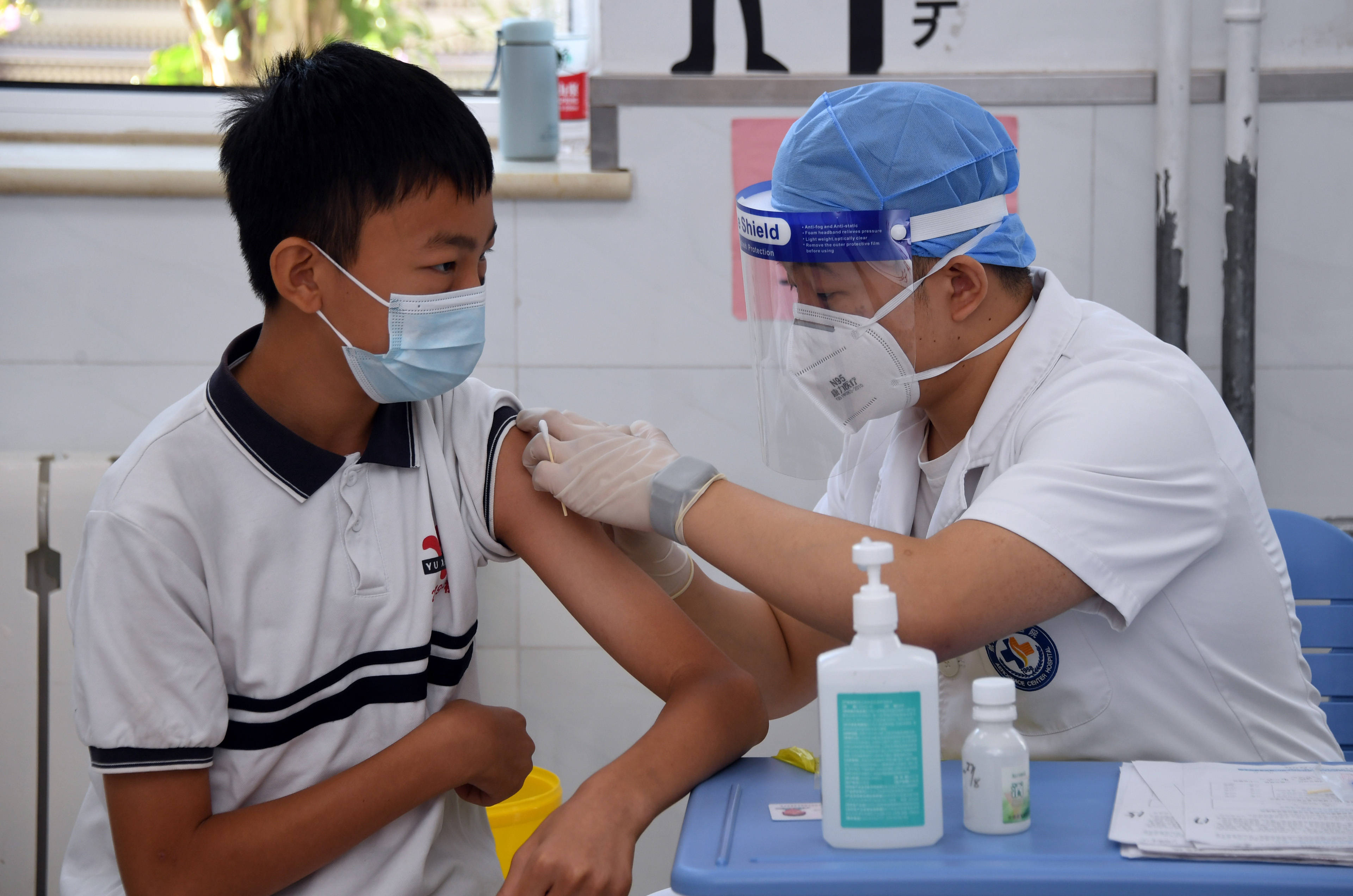 8月21日,在北京市育英学校航天校区,医护人员为学生接种新冠疫苗.