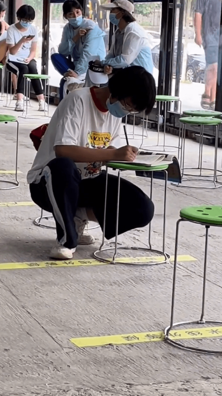 学生打完疫苗留观间隙蹲着学习,路人竖起大拇指