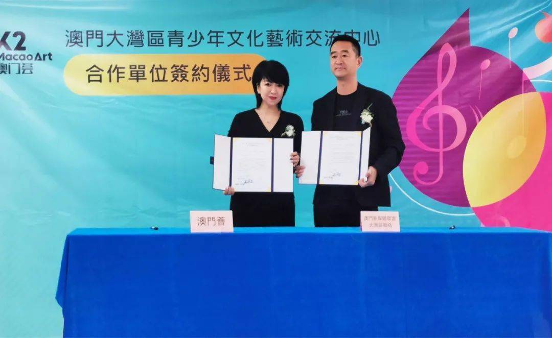 澳门文化交流协会会长伍迅波(左)与华承莲澳艺术中心副主任陈展伦签约