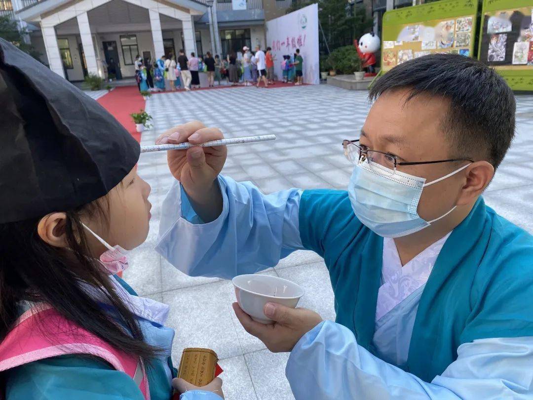 陈校长手托朱砂碗,为小竹娃们眉心绘一点朱砂,这就是所谓的"朱砂开智"