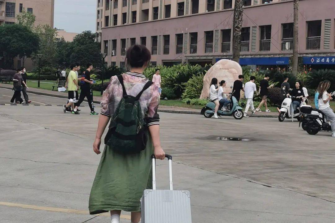 人群中再次出现一个与众不同的瘦小身影,她手里拖着一只硕大的行李箱