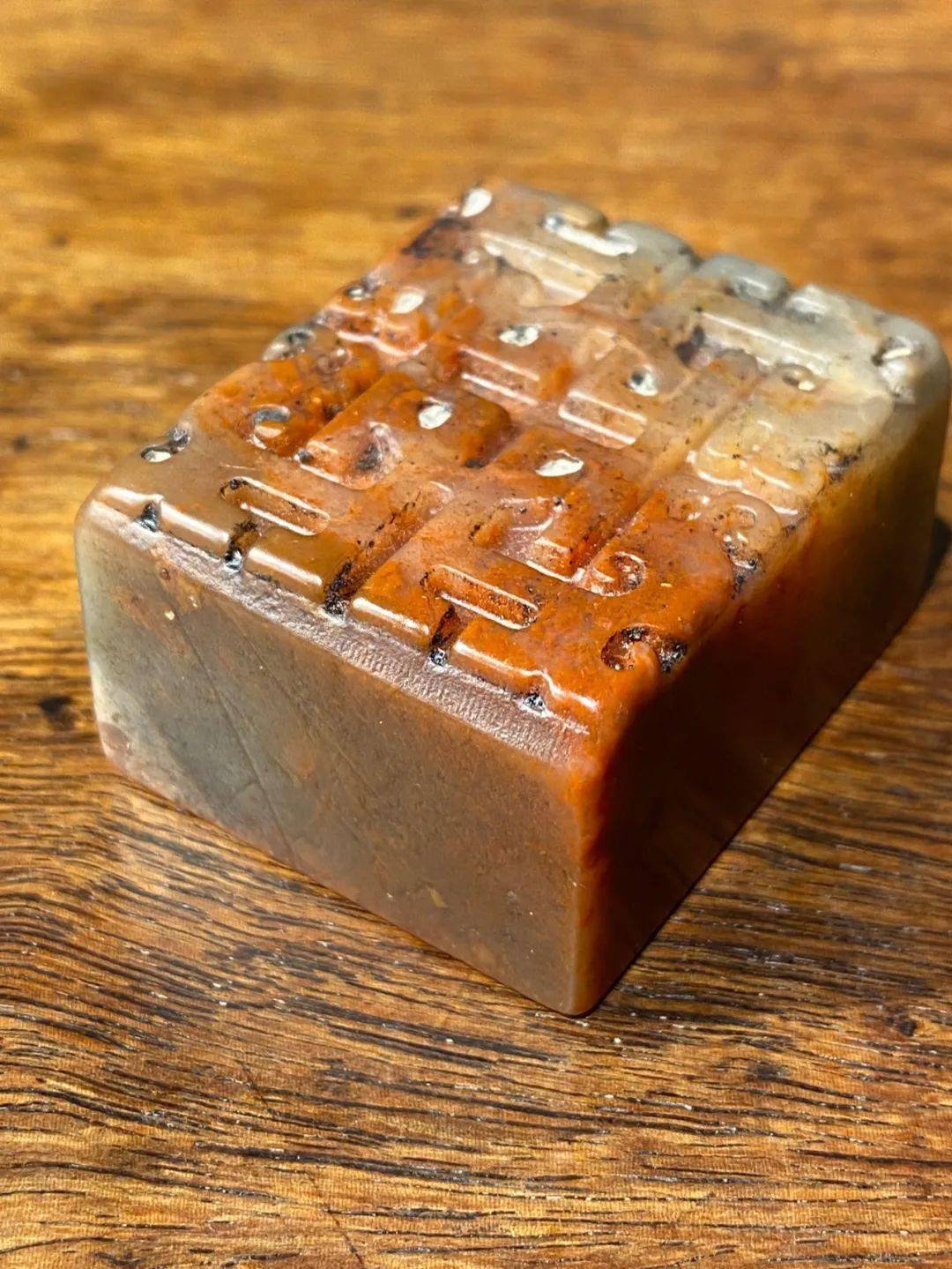 这是一方以产于福建寿山的芙蓉朱砂石雕刻而成的方形雕博古螭龙纹文人