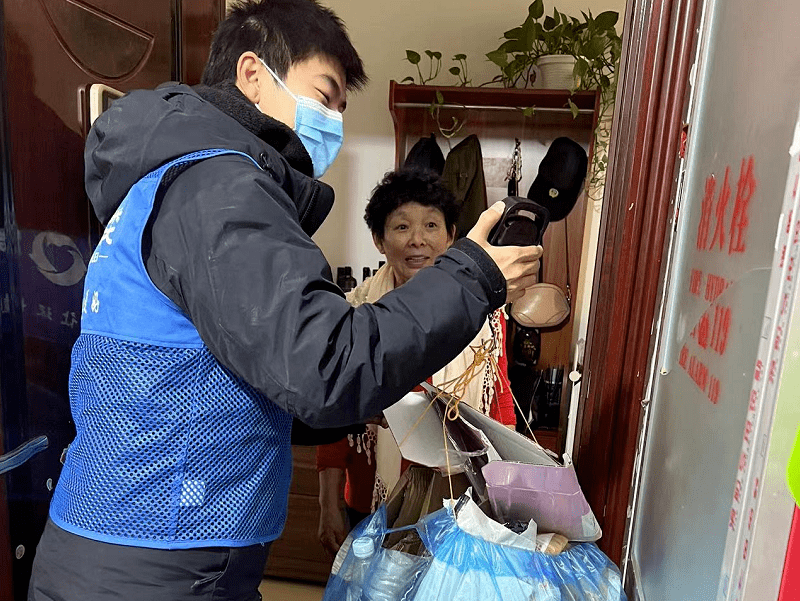 垃圾分类驿站,看到 一名工作人员热心地为居民讲解预约上门回收服务