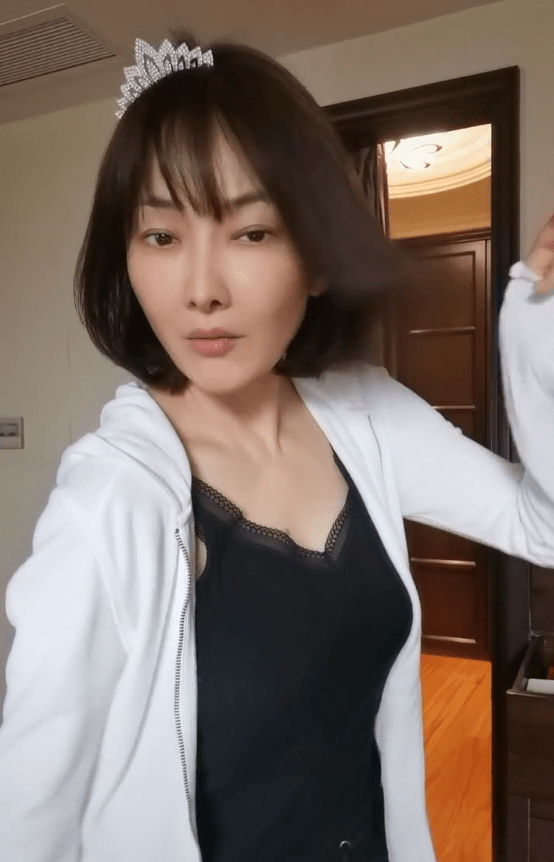 47岁牛莉扭腰热舞,穿蕾丝背心嘟嘴玩性感,侧身低领显丰满曲线_穿着