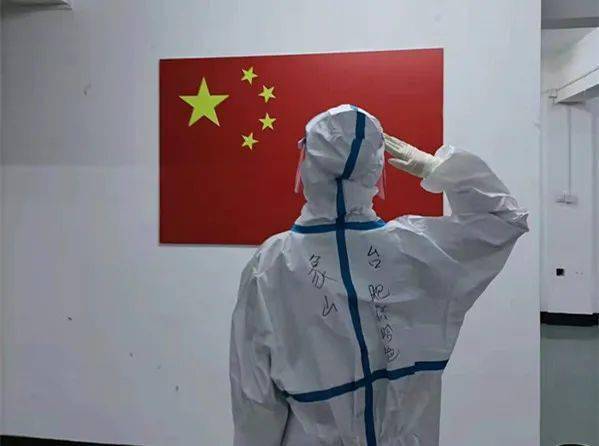 第一梯队第二组的医护人员,在镇海区九龙湖镇河头村村委会与国旗合影