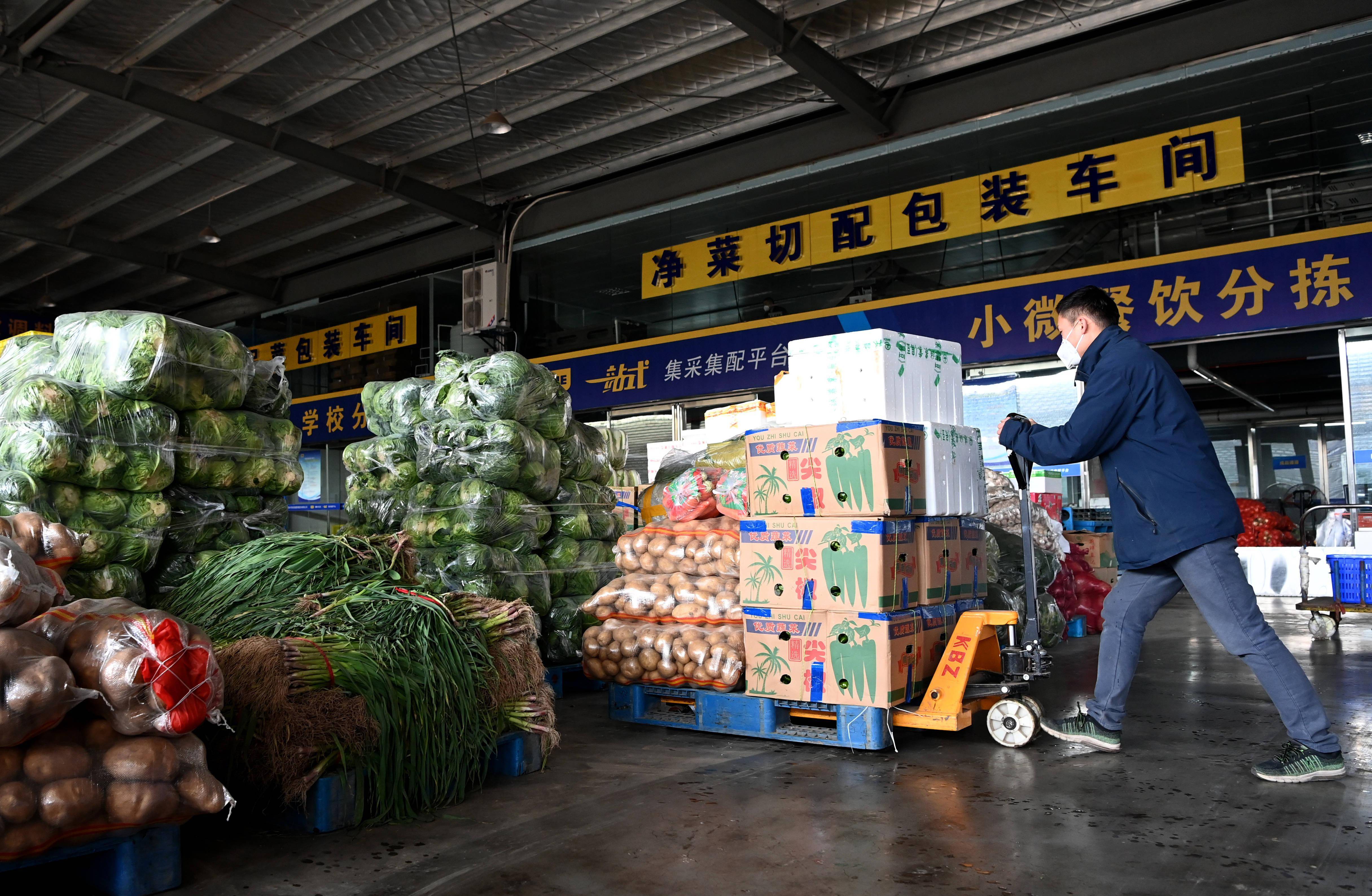 陕西米禾供应链管理股份有限公司的工作人员在分拣蔬菜(12月19日摄)