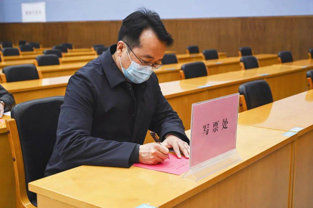 区委副书记,区长李亮以普通选民的身份参加投票选举,凭选民证领取选票