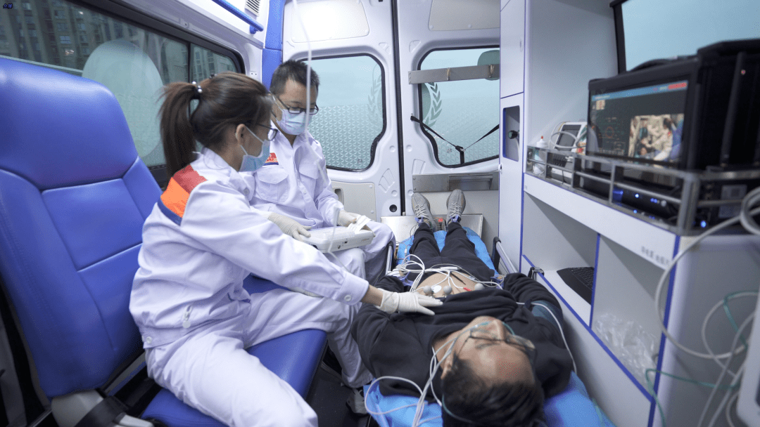 急救人员在高速交警的配合下,迅速将患者搬运上救护车,为患者连接心电