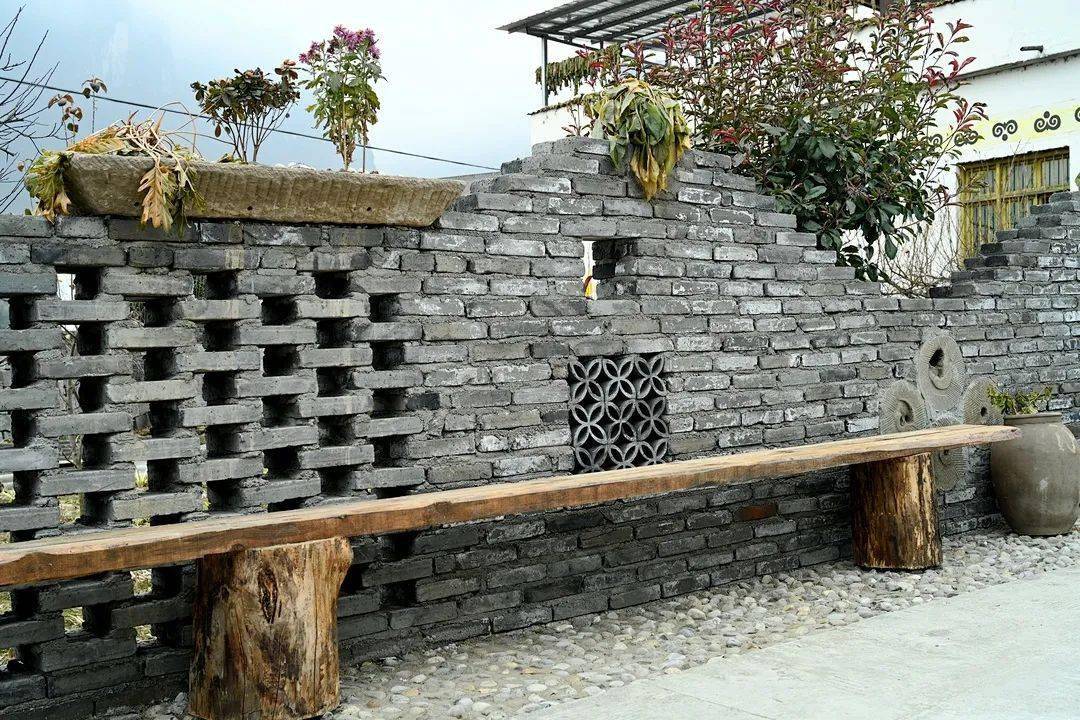 围墙经过重新打造,土罐镶嵌在围墙里,再栽上花草,创意十足;围墙上,放