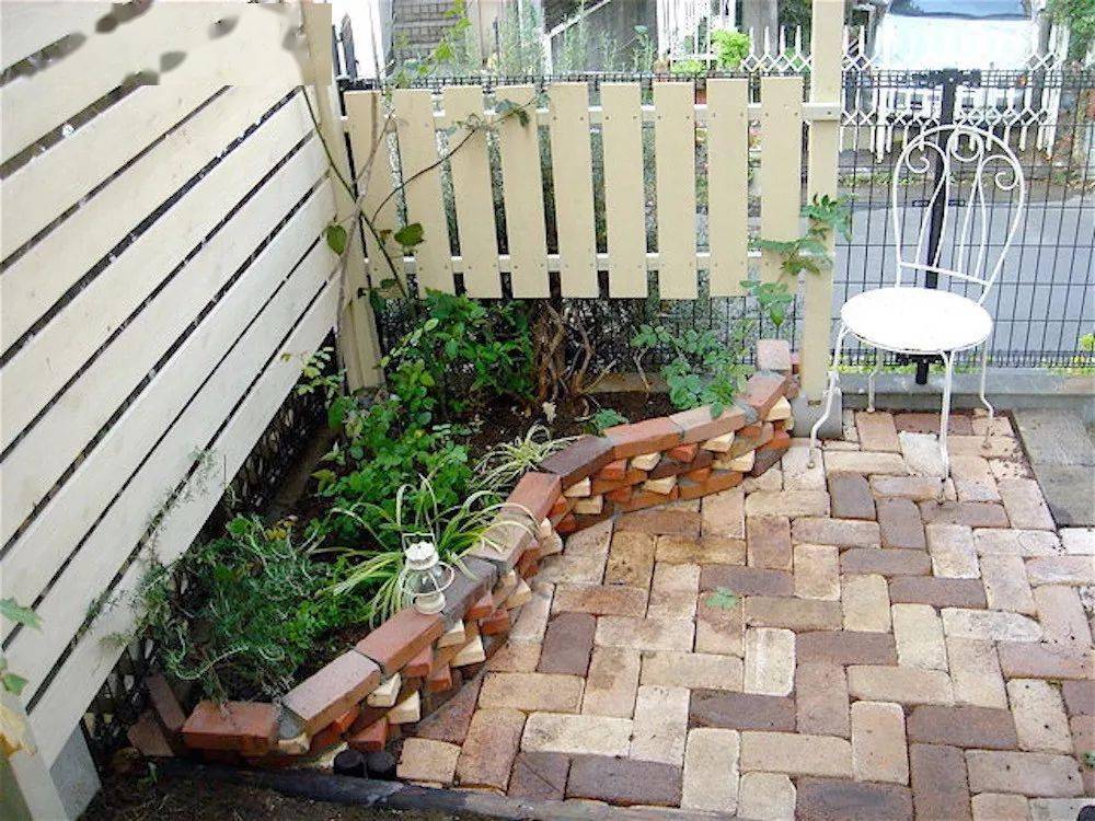 我买了很多砖头,在角落堆出了一个小花坛,还设置了一面小栅栏用来遮挡