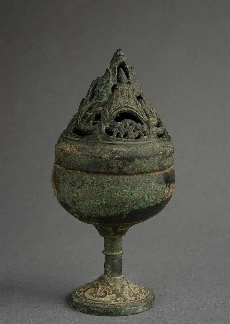 炉为青铜质,由盖和体两部分组成,子母口结合,盖呈镂雕山峦状,顶钮为一