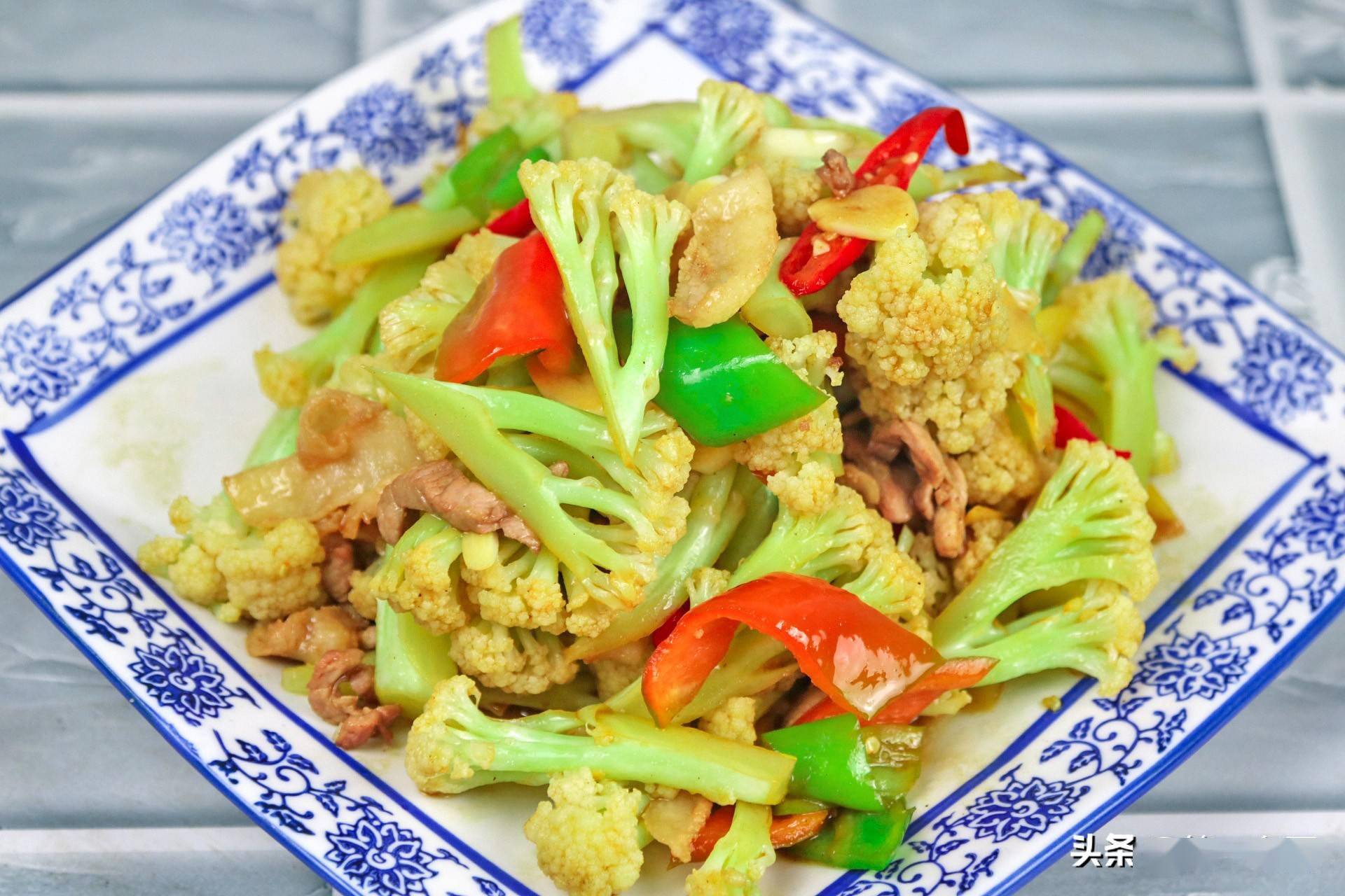 准备有机花菜半个切成小朵,红椒半个切成菱形片,青椒同样切成菱形片