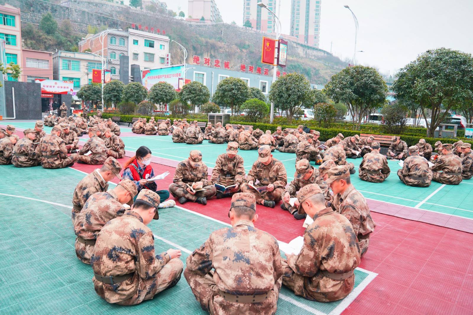 县文体广电局的志愿者们把流动图书服务车开到官兵们训练场,并一起和