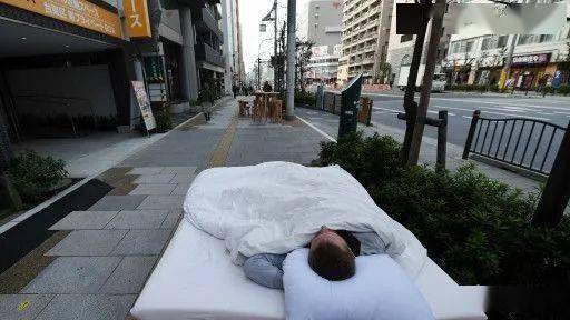 在路上睡觉,日本人不用担心他的东西会被人偷走,治安真不错啊……打