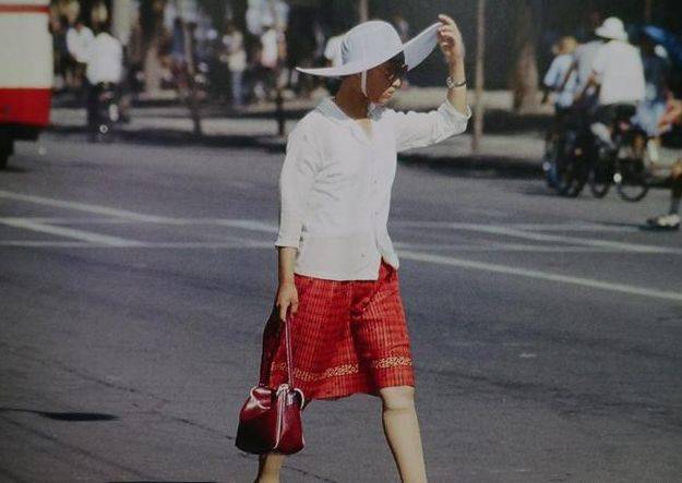 这名女子的打扮在80年代一定是最时尚的,白色的上衣搭配红色的裙子