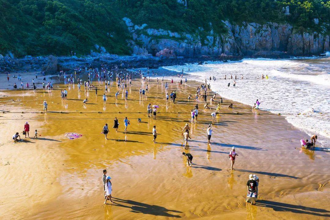 整个浴场呈半环抱形,平坦开阔,三面环山,一面朝海,金沙碧浪,与蓝天
