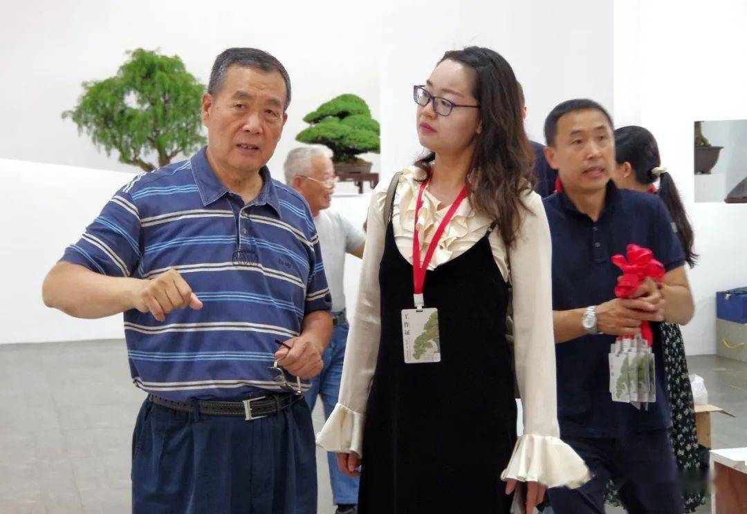 李克文少将与上海植物园盆景管理中心负责人王娟交流展览解说工作.