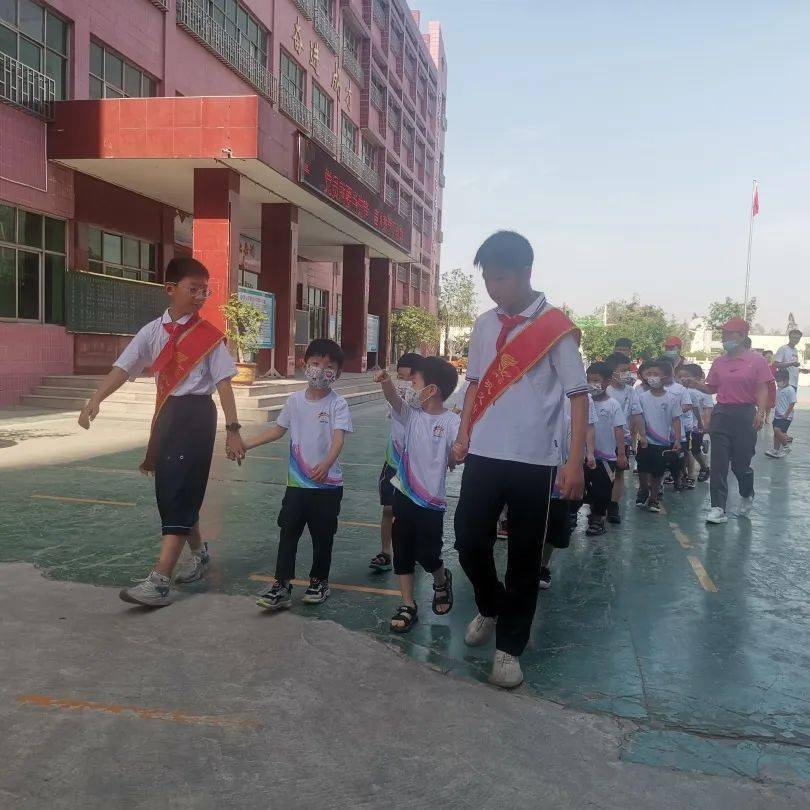 在老师的带领下,孩子们穿着整齐的校服,排着整齐的队伍,有序来到五小