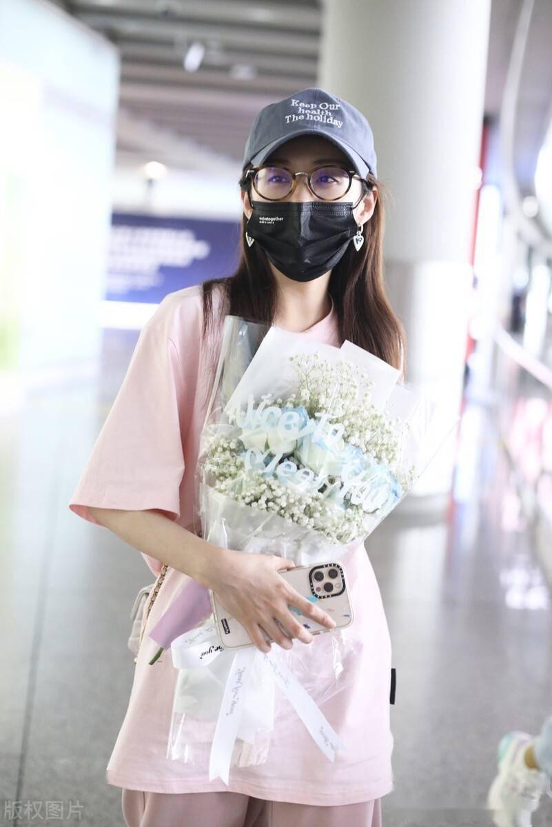 郑合惠子粉色短t搭卫裤现身机场捧鲜花人气旺