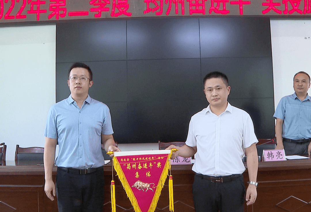 8月3日,县政府副县长陈龙向县经信商务科技局授旗.