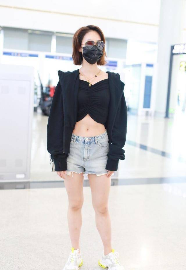 下图照片中,蓝盈莹穿了一件黑色露肚脐紧身上衣搭配黑色外套现