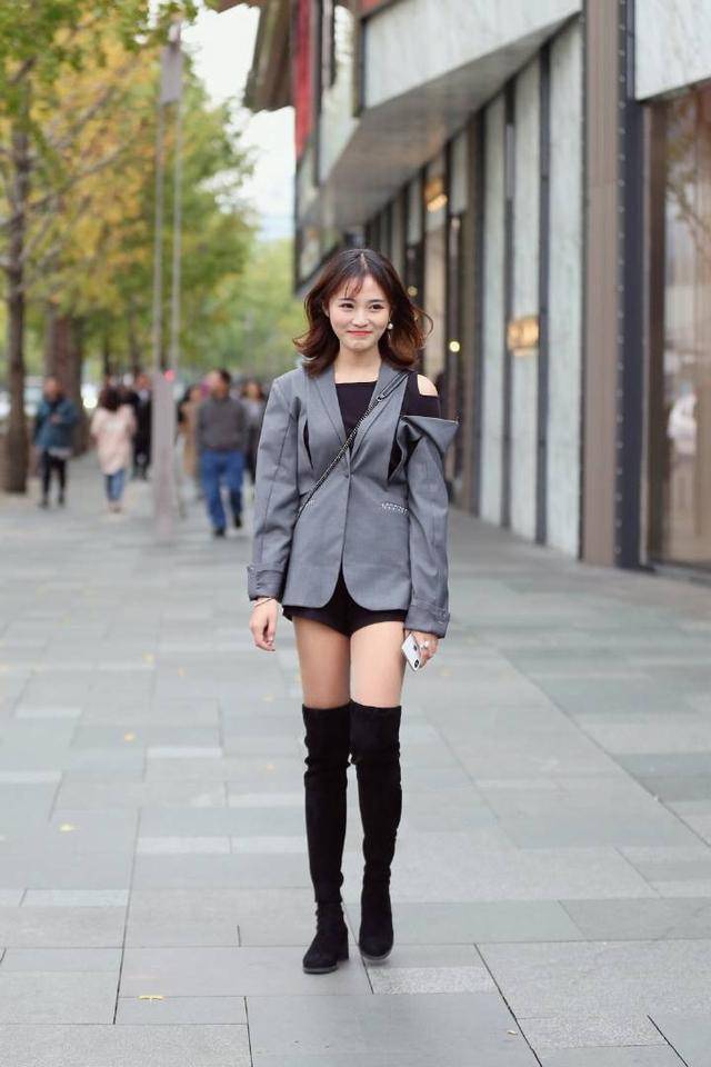 街拍中的小姐姐有着高挑的身材,她穿着黑色套装,看起来酷劲十足,让人