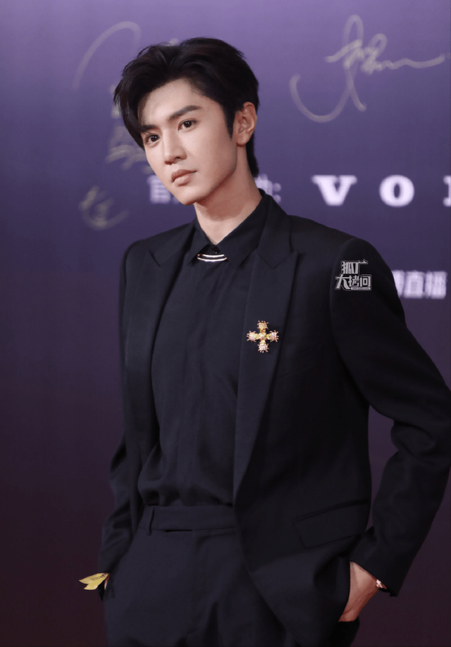 陈哲远从内到外一身黑,黑色polo衫配黑西装,领口用一枚十字形金色胸针