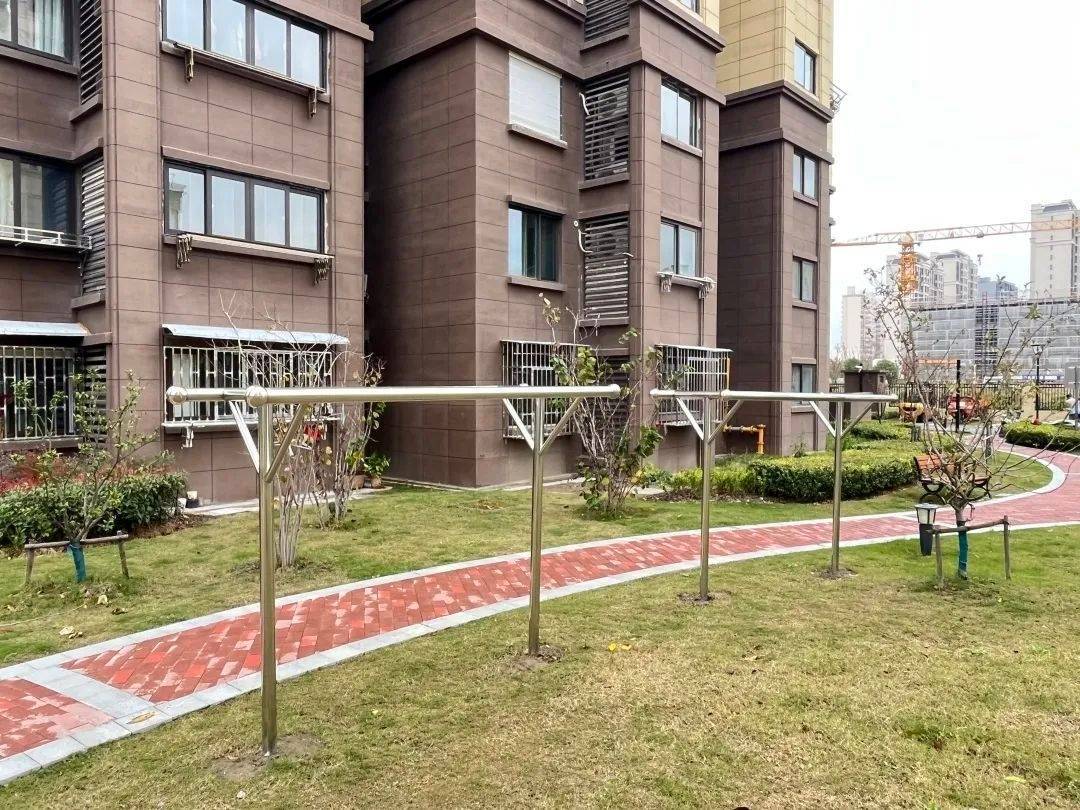 小区住宅楼层高,低层住户的光照时间短,需要把衣被拿到户外晾晒