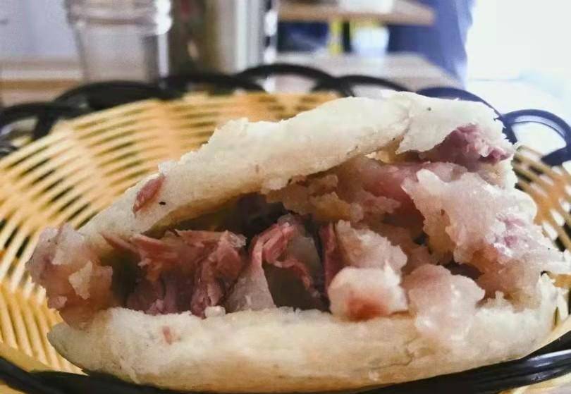 我进店里要了一个烧饼裹焖子肉,焖子肉软嫩,烧饼烤的酥脆,上面还撒着