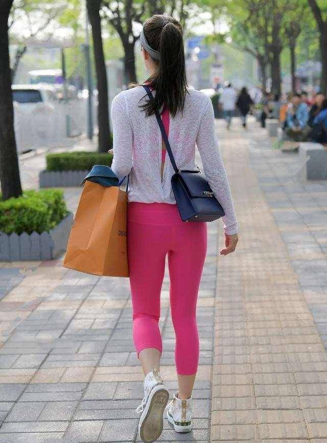 黑色打底裤搭配时尚同色系上衣,突出腰线,全身起到收