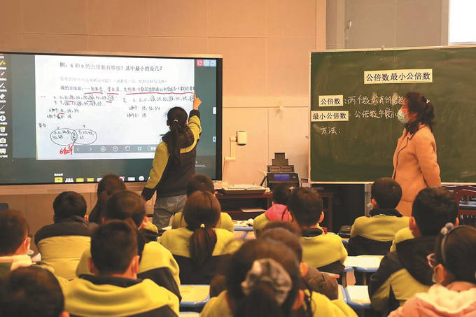 图为徐州商务城小学学生将作业上传到精准教学云平台,随堂扫描实时