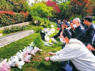 禮儀人員手捧逝者骨灰袋,整齊肅穆,緩緩步入磨盤山公墓恒生園花葬區