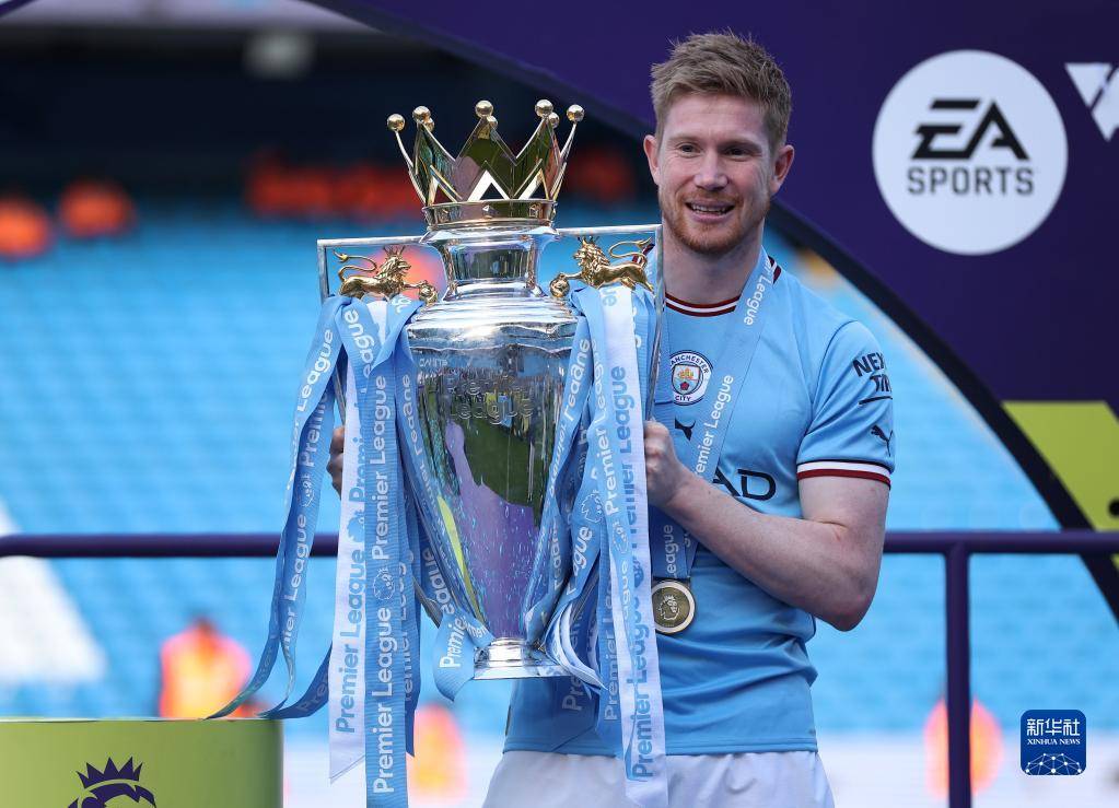 5月21日,曼彻斯特城队球员德布劳内手持英超冠军奖杯庆祝.新华社发