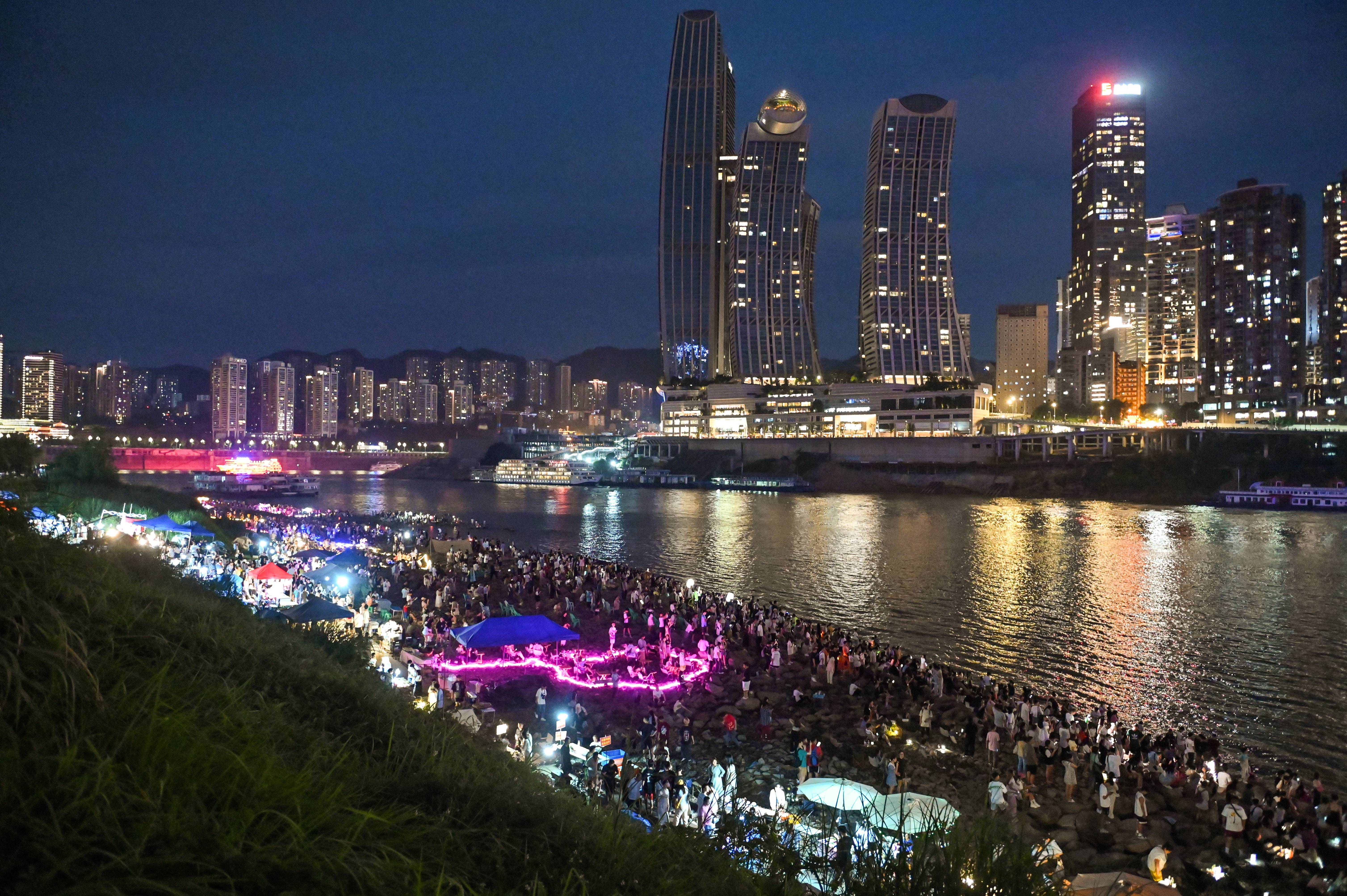 2023年7月18日晚,摊主正在重庆江北嘴江滩公园夜市上制作美食