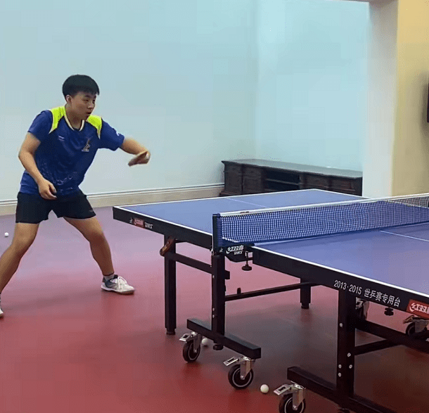 邓亚萍的老公林志刚站在旁边,夫妻俩排队排站好,手上拿着乒乓球拍