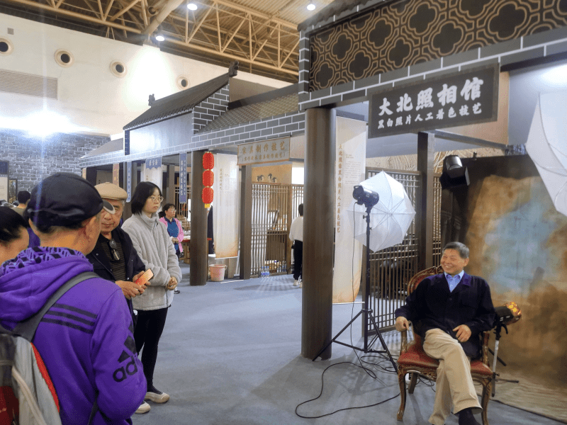 消费者在大北照相馆展位拍照留念.