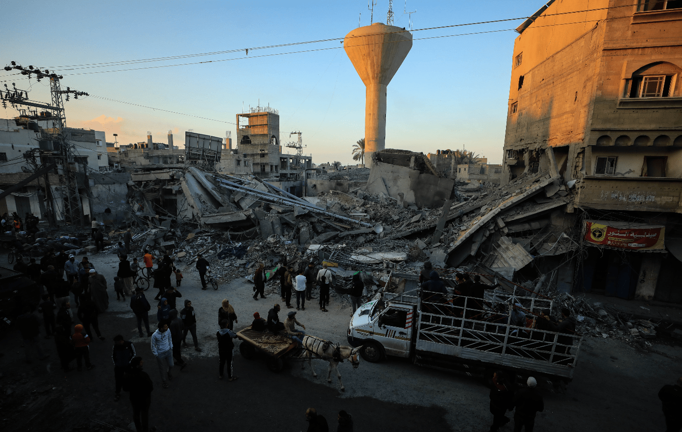 17日,在加沙地带南部城市汗尤尼斯,人们查看遭以色列袭击后的建筑废墟