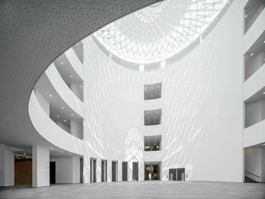 的面纱;如"花瓣"一般的外立面幕墙由21008片鱼鳞状的光伏玻璃人工拼接