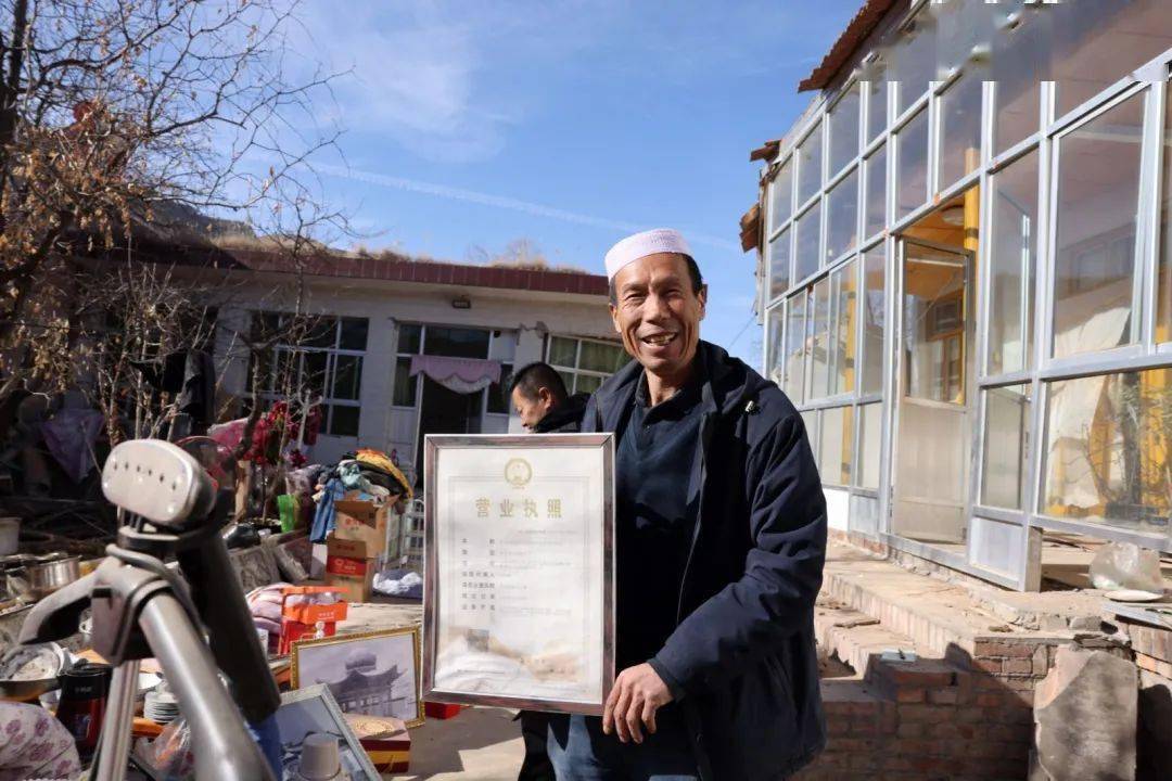 家镇克新民村养殖户何存佩正展示他地震后第一时间抢险拿回的营业执照